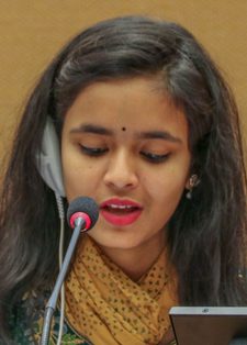 Young woman speaking at a podium with a microphone and earpiece