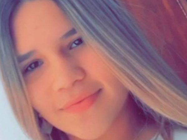 A young woman with long, straight hair smiles softly at the camera