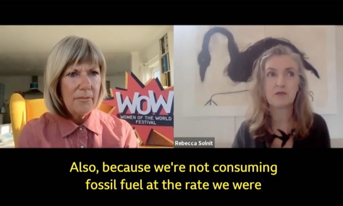 Two women speak in a video call for the WOW Festival, with subtitles discussing reduced fossil fuel consumption.